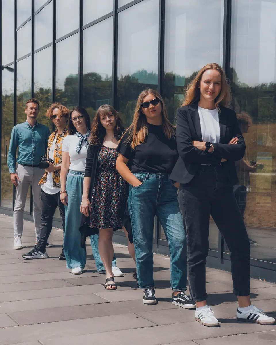 Zespół Social Media Now przed szklaną ścianą biurowca